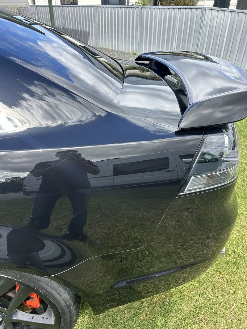 Reflection across a black Commodore rear quarter