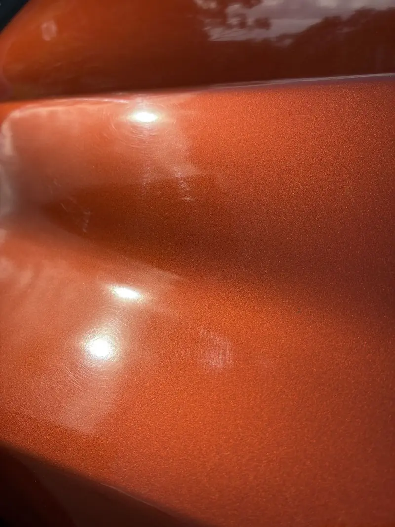Light running cleanly along finished orange paint on an Isuzu D-Max