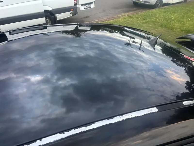 Clouds reflected in a black roof after coating