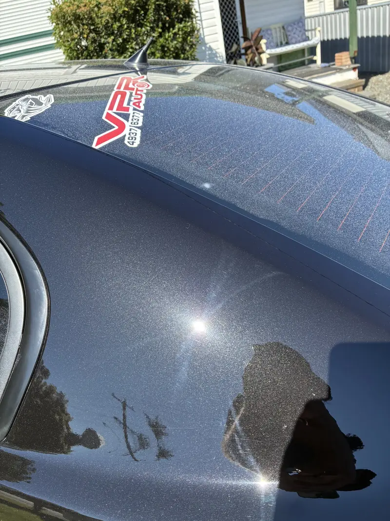 Swirl marks visible around the sun reflection on dark paint