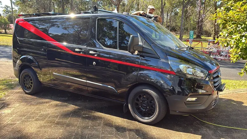 Black Ford Transit Custom with red stripe after coating
